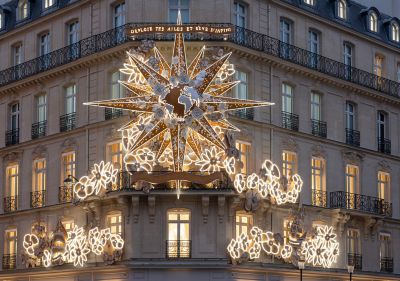 Edificio de Dior en París con una estrella y decoraciones florales iluminadas