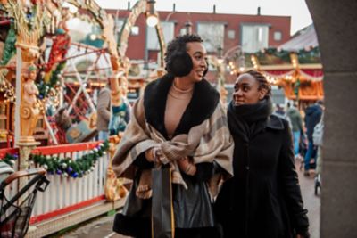 Deux amies qui se baladent dans les allées d’un marché de Noël aux Pays-Bas