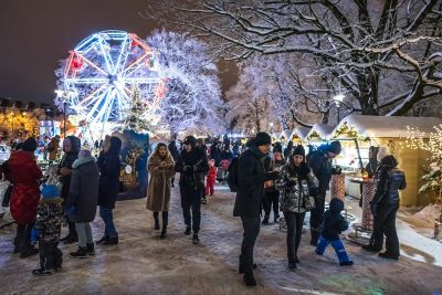 Crowds enjoying the stalls and Ferris wheel at Esplanade Park Christmas market in Riga