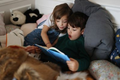 A pair of children preparing for a holiday by reading a book together