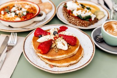 American pancakes with strawberries and a barista-made coffee in a restaurant
