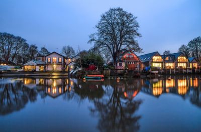 Houses illuminated in the evening on Eel Pie Island on the River Thames in Twickenham