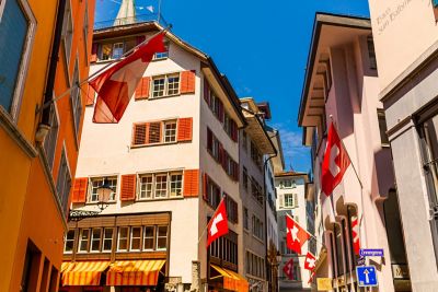 Schweizer Landesflaggen wehen an historischen Häusern in der Züricher Altstadt