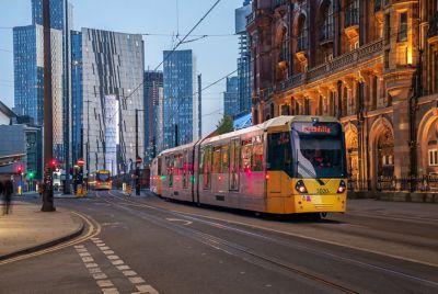 Tramway qui circule dans le centre-ville de Manchester à la nuit tombée