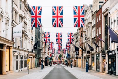 Geschäfte von Luxusmarken in der mit britischen Fahnen geschmückten Bond Street, London