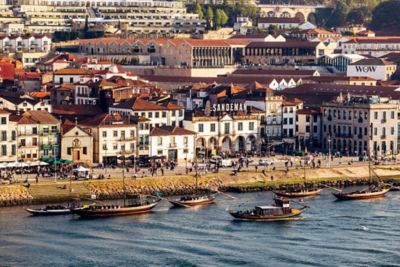 Buildings and people lining the Vila Nova de Gaia waterfront in Porto
