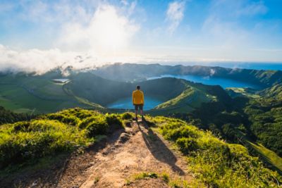 Vista panorámica de la Lagoa das Sete Cidades en Azores con un hombre admirando el paisaje