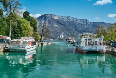 Sightseers boarding cruise boats on turquoise Lake Annecy, France