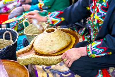 Amazigh (Berber) woman in Morocco dressed in colourful clothing making argan oil paste