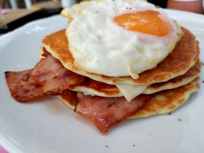 Pancakes with bacon and a fried egg in a restaurant