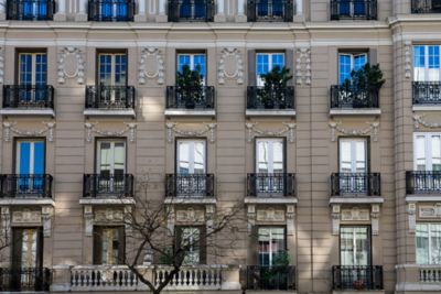 Fachada tradicional de un edificio en Madrid, con ventanas ornamentales y balcones de hierro