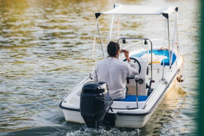 A self-driver cruising in a small motorboat on a river