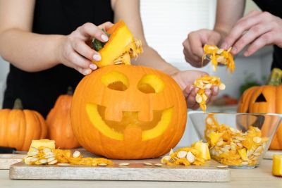 Pumpkin carvers decorating their jack-o'-lanterns with the scooped-out insides
