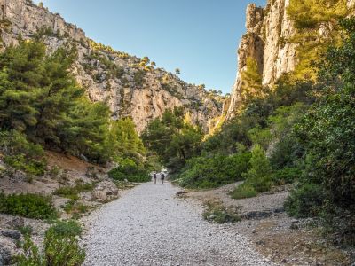 Zwei Wanderer zwischen hohen Felsen im Nationalpark Calanques bei Marseille