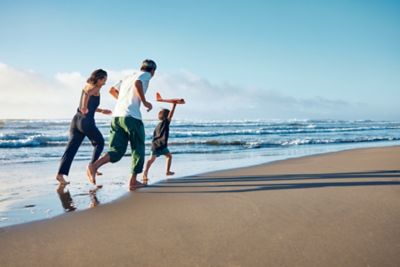 Famille qui court sur la plage 