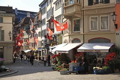 A cobbled street in Zurich with flower shops, cafés and a quaint square