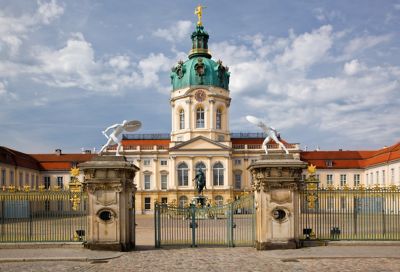 Barockes Schloss Charlottenburg in Berlin in Frontalansicht mit verziertem Eisentor davor