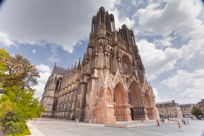 Visiteurs qui se dirigent vers les grandes portes pour visiter la cathédrale de Reims