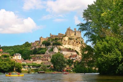 Groupe de kayakistes sur la Dordogne longeant un village