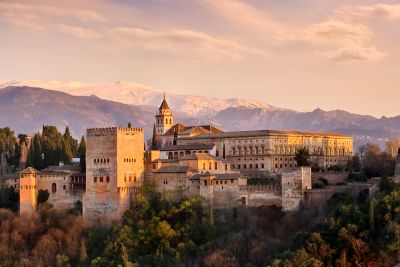 La Alhambra al atardecer con las montañas de Sierra Nevada al fondo.