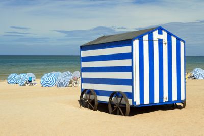A striped blue-and-white cabin overlooking the North Sea on De Panne beach, Belgium