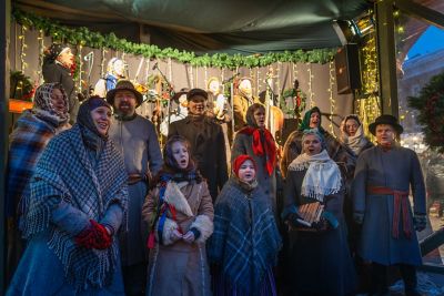 Warmly dressed folk singers performing at a Riga Christmas market