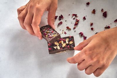 Handgemachte, frisch gefertigte Schokolade mit Nüssen und Blütenblättern