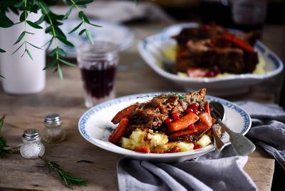 Bœuf braisé avec légumes et purée, servi avec un verre de vin rouge dans un bistrot parisien