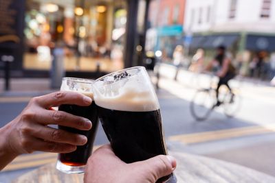 A toast being made with two glasses of Guinness in Dublin city centre