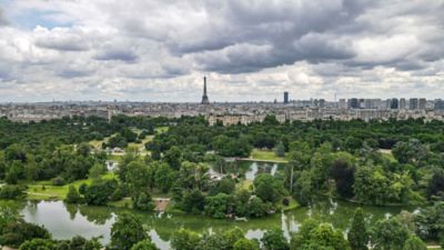 Der Pariser Park Bois de Boulogne mit der Skyline von Paris vor wolkenverhangenem Himmel