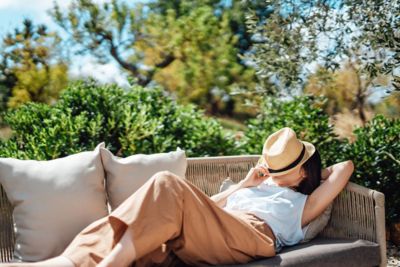 A person enjoying a rest in the sunshine surrounded by greenery