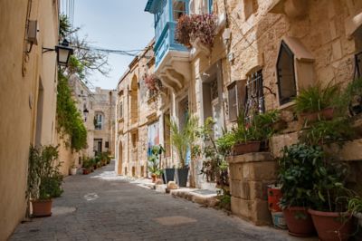 Shaded alleyway lined with golden buildings in the Silent City of Mdina, Malta