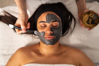 A wellness seeker receiving a mud facial mask in an elegant spa