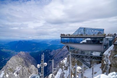 The summit of Zugspitze, with a glass observation deck overlooking rugged peaks