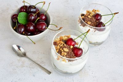 Glass pots of cherry-topped yoghurt, like those found at a Novotel breakfast buffet