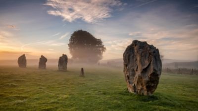 Dramatic Avebury Stone Circle in Wiltshire wreathed in a morning mist