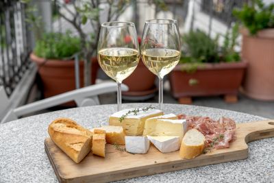 Planche de fromage français et de charcuterie, avec pain et verres de vin blanc
