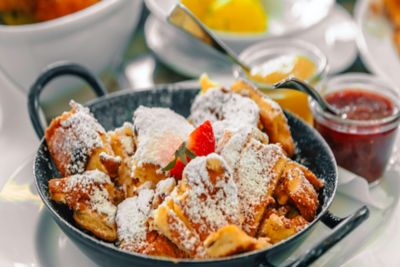 Portion Kaiserschmarn mit Puderzucker und Erdbeergarnitur in einem Wiener Restaurant