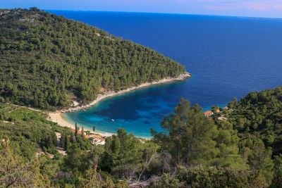 Pupnatska Luka bay with a quiet shore and calm blue waters surrounded by forested cliffs