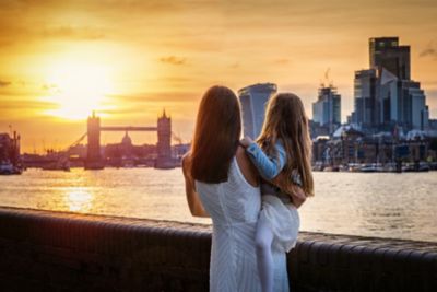 Une mère et sa fille qui admirent le coucher de soleil face au Tower Bridge de Londres