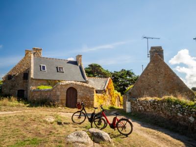 A pair of parked bicycles in front of traditional stone houses in Brittany, France