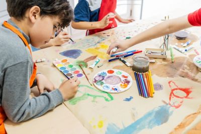 A child painting on kraft paper with his friends