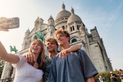 Selfie-taking teenagers in front of the Sacré-Cœur Basilica in Montmartre, Paris