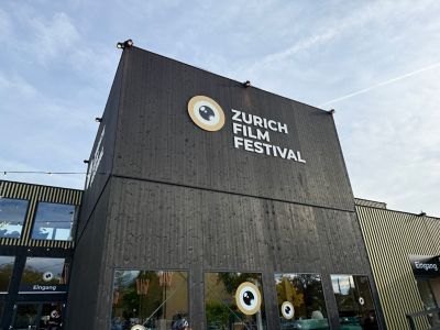 Hölzernes Eingangsgebäude des Zurich Film Festivals mit Aufschrift und Logo des Festes