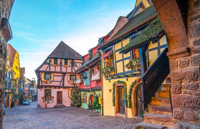 Pastel half-timbered houses lining cobbled streets in Riquewihr village, Alsace