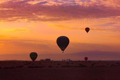 Hot-air balloons over the Moroccan desert with the Atlas Mountains in the background