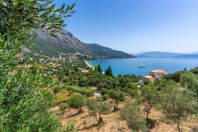 Secluded Barbati Beach in Corfu, Greece, with rugged mountains overlooking the blue Ionian Sea