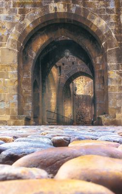The cobbled path and weathered stone archway of Carcassonne's main entrance