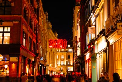 Revellers pack cocktail bars lining Carnaby Street in Soho, London