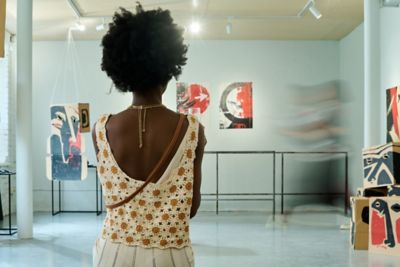 A visitor gazing at an abstract canvas and installations in an art gallery